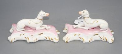 A pair of Staffordshire porcelain figures of recumbent greyhounds, c.1835-50, each on pink and