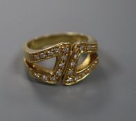 A modern 18ct gold and diamond set stylised buckle ring, size M, gross 7.8 grams.CONDITION: Minor