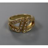 A modern 18ct gold and diamond set stylised buckle ring, size M, gross 7.8 grams.CONDITION: Minor