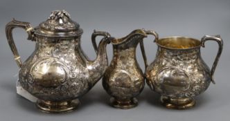 A Victorian embossed silver pear shaped three piece tea set, William Gough, Birmingham, 1863,