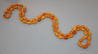 A single strand barrel shaped amber bead necklace, 124cm, gross weight 75 grams.CONDITION: One