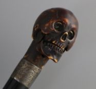 An ivory metamorphic skull cane handle, length 23.5cm