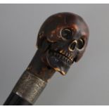 An ivory metamorphic skull cane handle, length 23.5cm