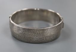 A 1970's textured silver hinged bracelet, with checkered decoration, by Rigby & Wilson, gross 46