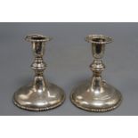 A pair of silver dwarf candlesticks, crested, marked rubbed, one a.f. to top (dented and lead