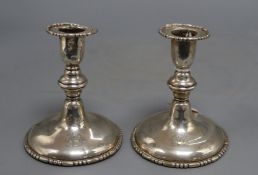 A pair of silver dwarf candlesticks, crested, marked rubbed, one a.f. to top (dented and lead
