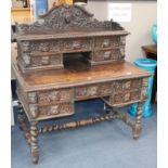 A late Victorian carved oak kneehole desk, W.120cm., D.74cm., H.131cm.