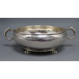 A George V planished silver two handle shallow fruit bowl, on four lobed feet, Goldsmiths &