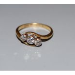 An 18ct and Pt, three stone diamond crossover ring, size M/N, gross 3 grams.CONDITION: One of the