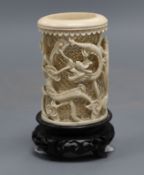 A Chinese carved and pierced ivory 'dragon' vase, wood stand, overall height 11.5cm