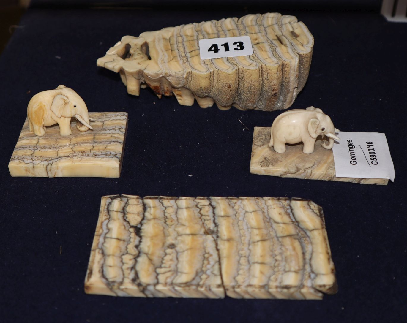 Two ivory elephant figures with elephant tooth stands and two elephant tooth specimens, early 20th