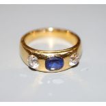 A yellow metal (stamped 22) gypsy set sapphire and diamond three stone ring, with GCS report dated