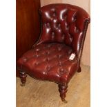 A Victorian style slipper chair upholstered in buttoned burgundy leather