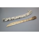 An eskimo scrimshaw elk bone and a similar paper knife, 22 and 23cm