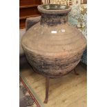 A large glazed pottery oil jar, on wrought iron stand, H.102cm