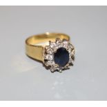 A modern 18ct gold, sapphire and diamond oval cluster ring, size M, gross 6.7 grams.CONDITION: One