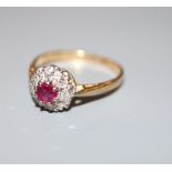 A mid 20th century yellow metal (stamped 18ct and Plat), ruby and diamond cluster ring, size L/M,