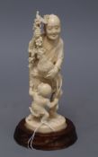 A Japanese ivory okimono group of a gentleman, a cockerel and a young boy, overall height