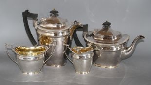 A silver plated four piece tea set, with an associated pair of plated sugar tongsCONDITION: Needs