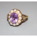 A 9ct, amethyst and split pearl set oval dress ring, size L, gross 3.6 grams.CONDITION: Two pearls