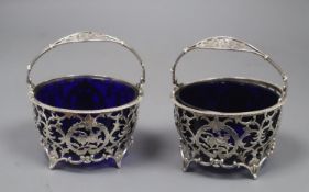 A matched pair of early 20th century pierced silver circular baskets, with blue glass liners, Horton