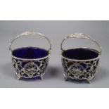 A matched pair of early 20th century pierced silver circular baskets, with blue glass liners, Horton