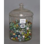 A glass jar and cover containing Victorian and later coloured marbles, height 26.5cm