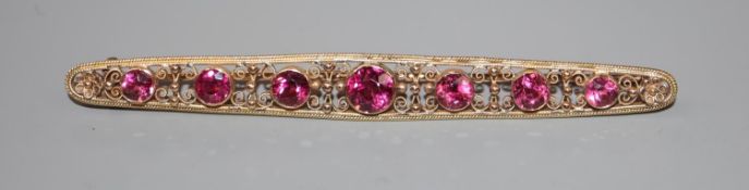 An early 20th century yellow metal and graduated pink tourmaline set bar brooch, 82mm, gross 6.4