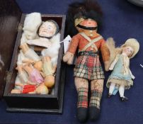 A German double sided pin doll head and seven other small dolls