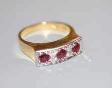 A modern 18ct yellow metal, three stone ruby and four stone diamond half hoop ring, size O, gross