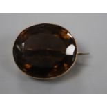 An early 20th century 15ct mounted oval brown quartz brooch, 25mm, gross weight 10.6 grams.
