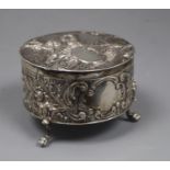 A continental embossed 800 standard white metal circular box with hinged cover, on three paw feet,