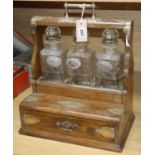 An oak and brass tantalus, with three decanters