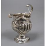 An early George III silver cream jug, London, 1764, with later embossed decoration, 12cm, 4 oz.