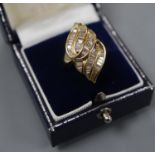 An 18k and trapeze cut diamond cluster set modernist dress ring, size L, gross 8.4 grams.