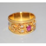 A modern yellow metal, cabochon ruby and diamond set band, with ropetwist decoration, size P,