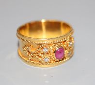 A modern yellow metal, cabochon ruby and diamond set band, with ropetwist decoration, size P,