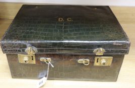 A crocodile skin travelling toilet case, containing silver topped glass jars, case 45.5cm