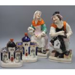 A pair of large Staffordshire pottery figures of the cobbler and his wife and a pair of
