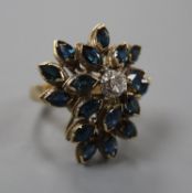 A 14k yellow metal, sapphire and diamond set raised cluster dress ring, of flowerhead design, size