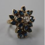 A 14k yellow metal, sapphire and diamond set raised cluster dress ring, of flowerhead design, size