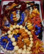 A quantity of assorted costume necklaces including amber, coral, blue glass and bone.