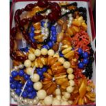 A quantity of assorted costume necklaces including amber, coral, blue glass and bone.