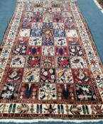 A Persian Garden rug, red, blue and ivory ground with bird and flower motifs, 305 x 169cm