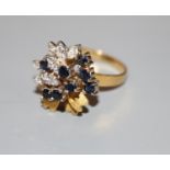 A modern 18ct gold, sapphire and diamond raised cluster dress ring, size N, gross 7.4 grams.