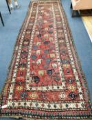 A Gendje red ground runner, c.1900, with polychrome field of stylised pears and multi row border,