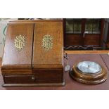 An oak stationery cabinet with brass monograms, 39 x 36cm, together with an oak aneroid barometer