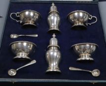 A cased silver six piece condiment set and three (ex four) spoons, William Comyns & Sons Ltd,