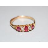 A yellow metal, ruby and diamond set five stone half hoop ring, size P, gross weight 2.2 grams.