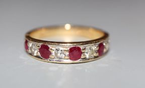 A modern 18ct gold, ruby and diamond set nine stone half hoop ring, size M, gross 3.2 grams.